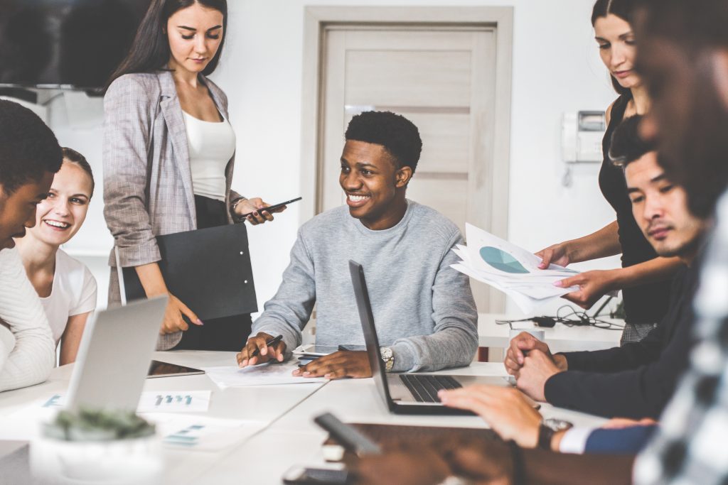 a team of young office workers, businessmen with laptop working at the table, communicating together in an office. corporate businessteam and manager in a meeting. coworking.