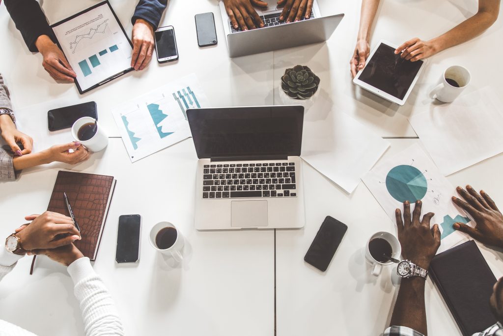 top view work workplace. a team of young office workers, businessmen with laptop working at the table, communicating together in an office. corporate businessteam and manager in a meeting. coworking.